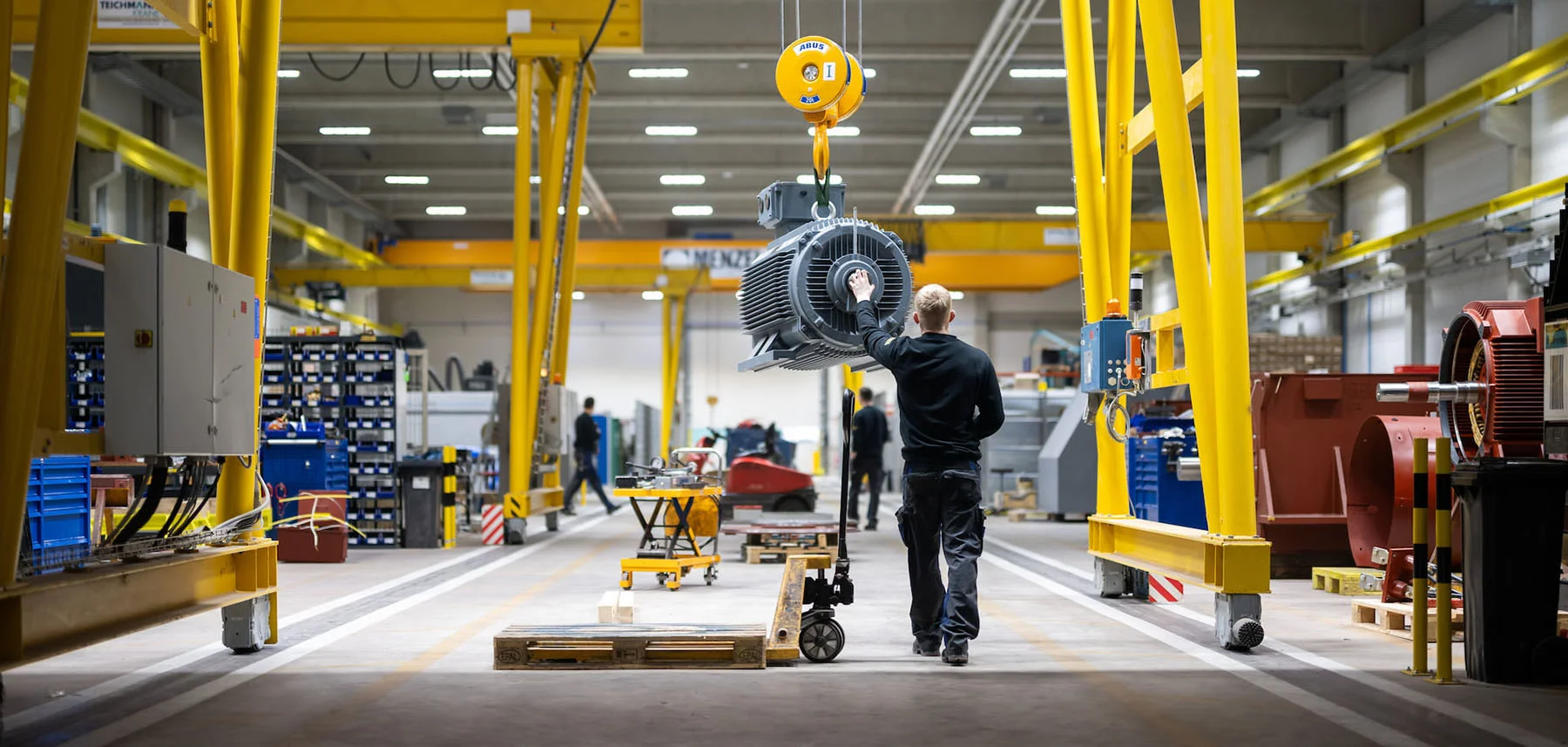 Crane transport of an electric motor through Menzel production hall